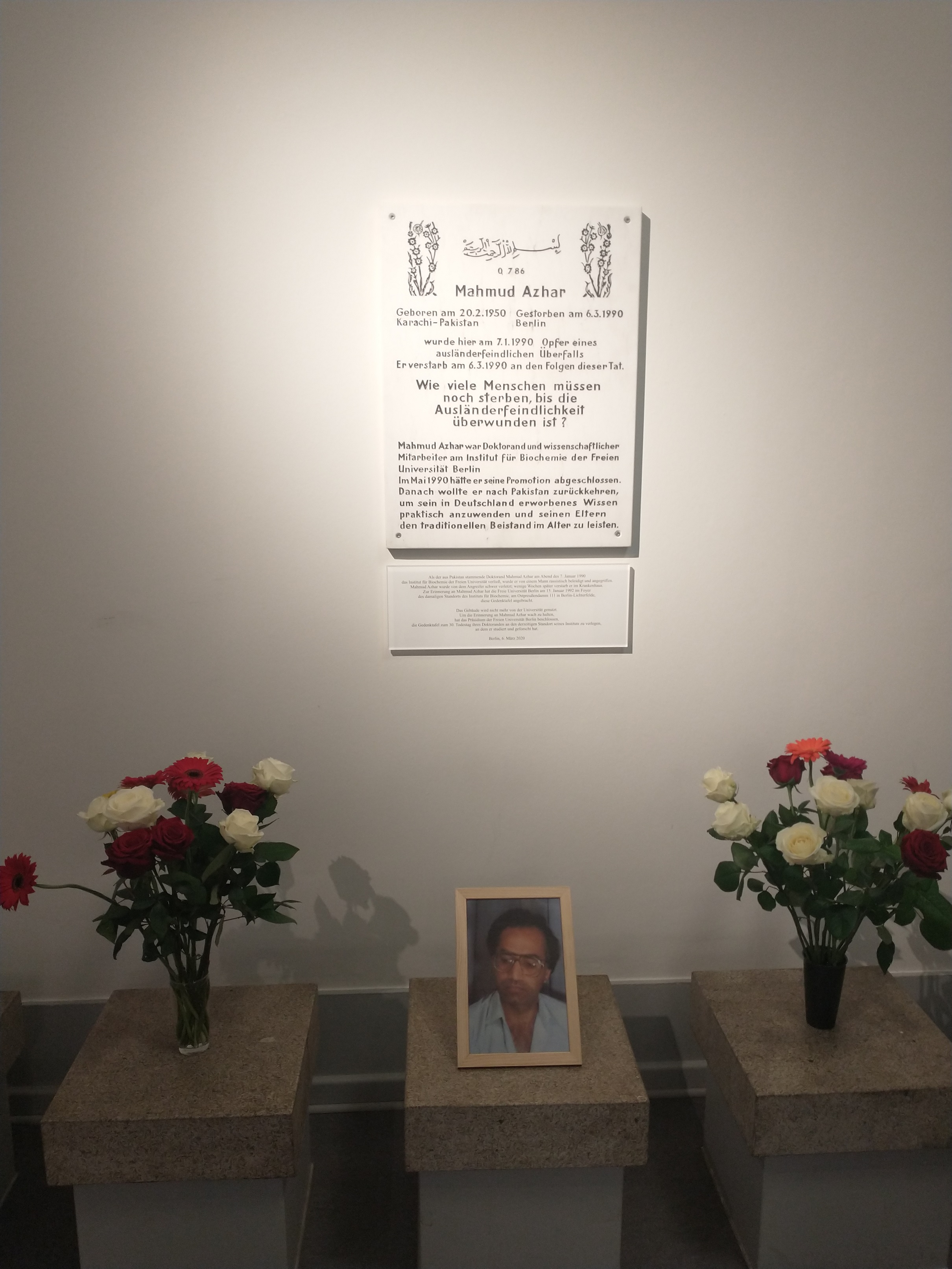 Gedenktafel an Mahmud Azhar, vor der ein Porträt Azhars und zwei Vasen mit Blumen stehen.
